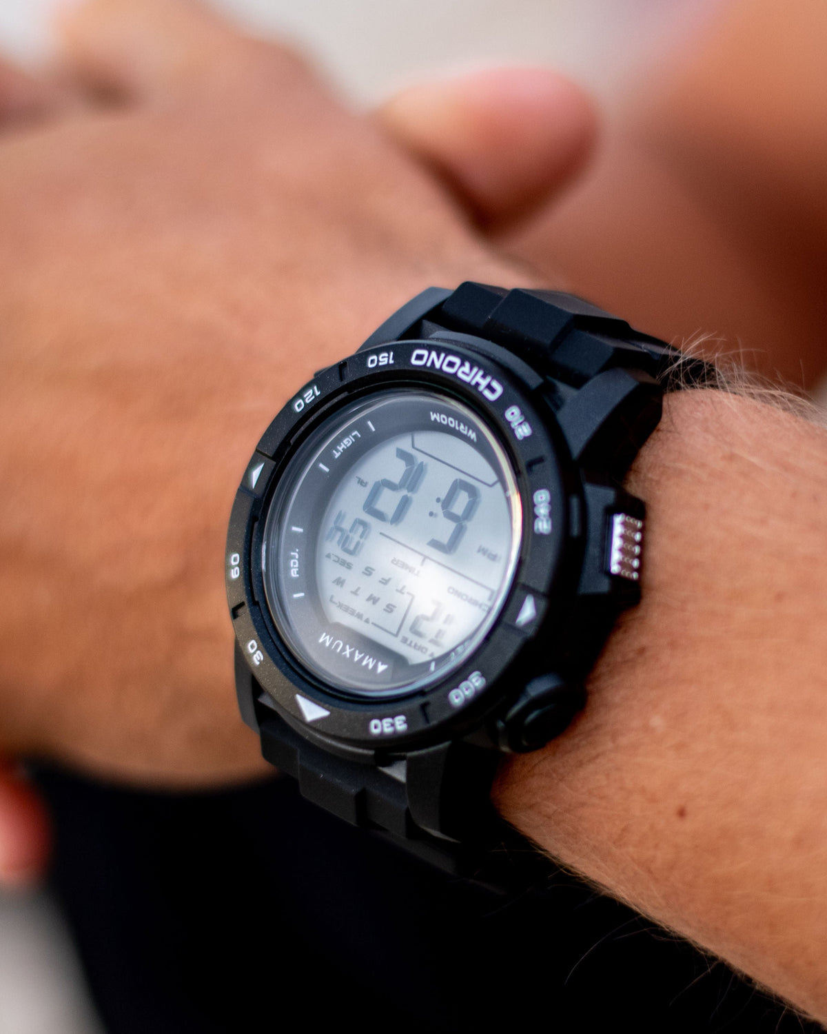 Maxum Basalt Black Digital Watch h on a person's wrist with a blurred background