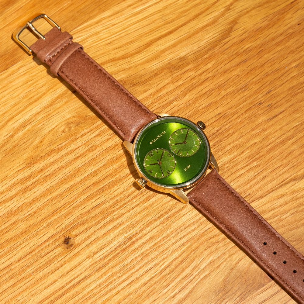 Maxum Taylor Steele Collaboration Watch with a green dial, gold-tone case, and brown leather band,