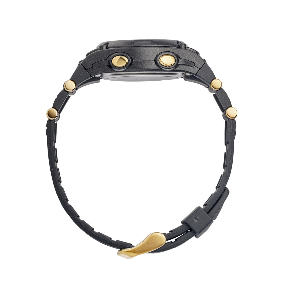 watch with a resin strap and buckle closure. The watch has a digital display with gold-coloured accents on the casing. Side view