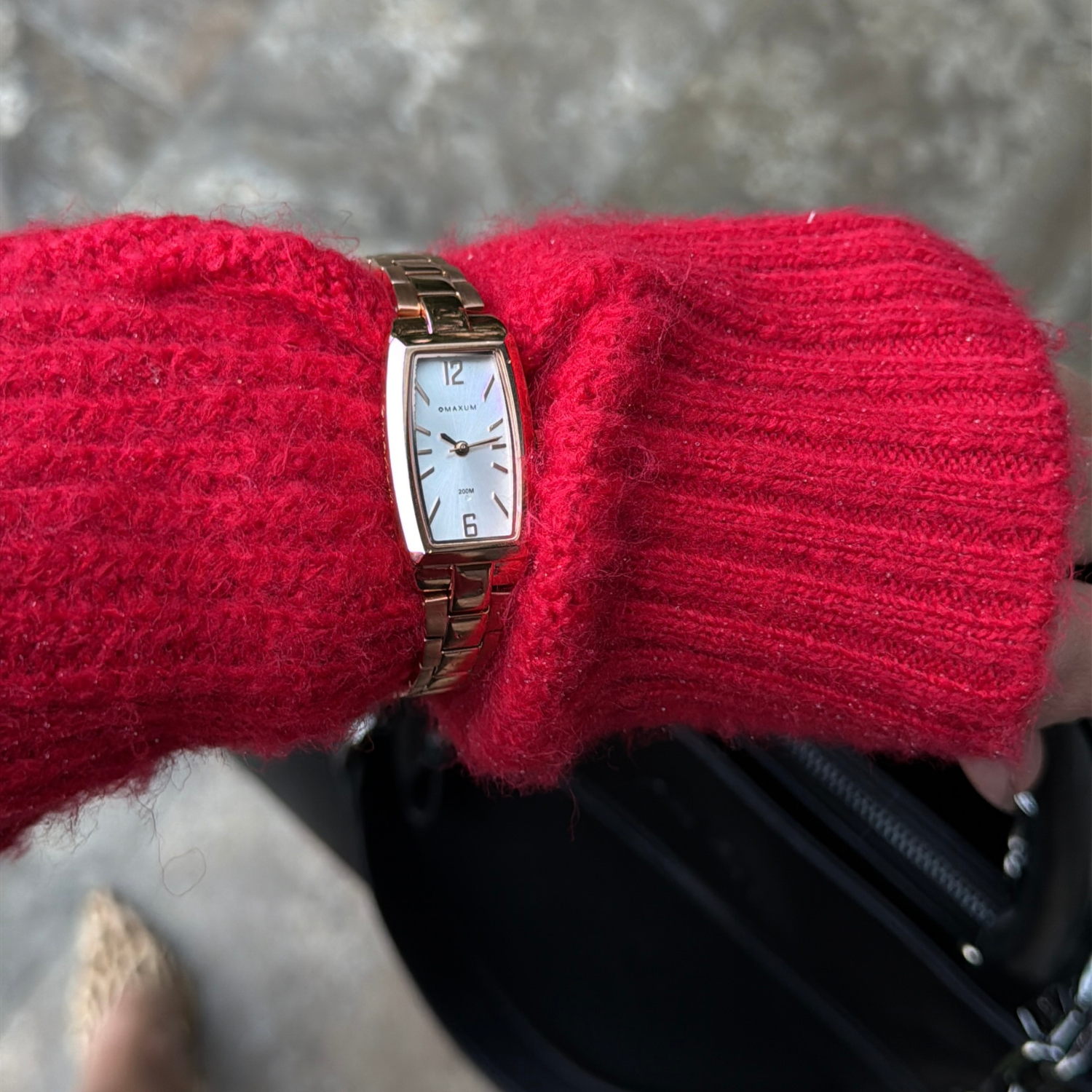 Maxum Fanta Reissue Rectangular rose gold-tone rectangular analogue watch with a white dial and a stainless steel bracelet. On wirst shot woman wearing red jumper